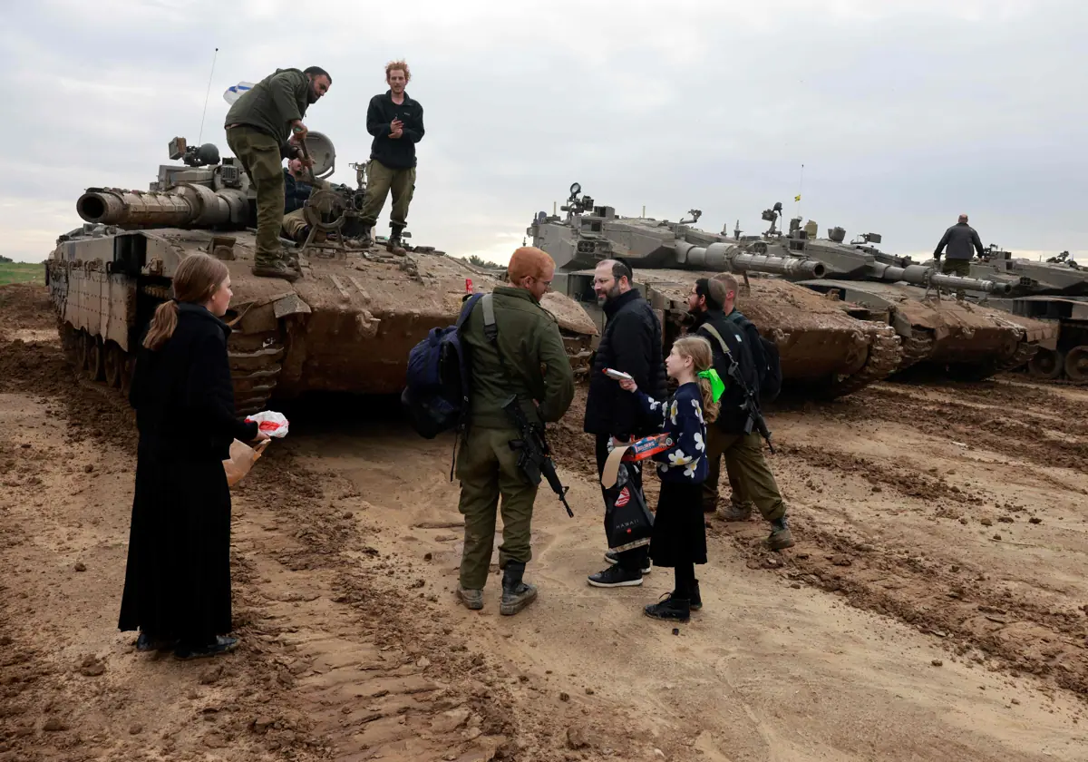 Jóvenes israelíes ultraortodoxos distribuyen dulces a soldados cerca de Gaza en Francia