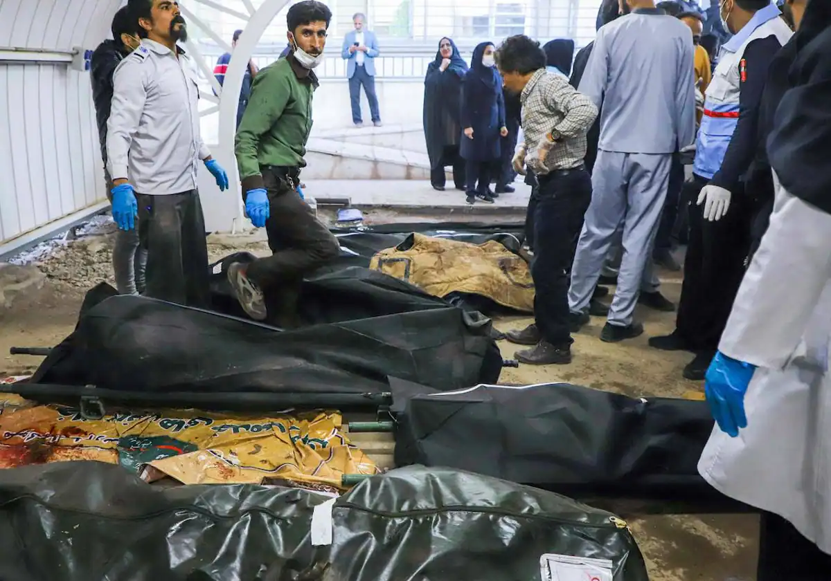 Un grupo de personas se reúne junto al cuerpo de las víctimas del doble atentado que causó décadas de muerte en Kermán (Irán)
