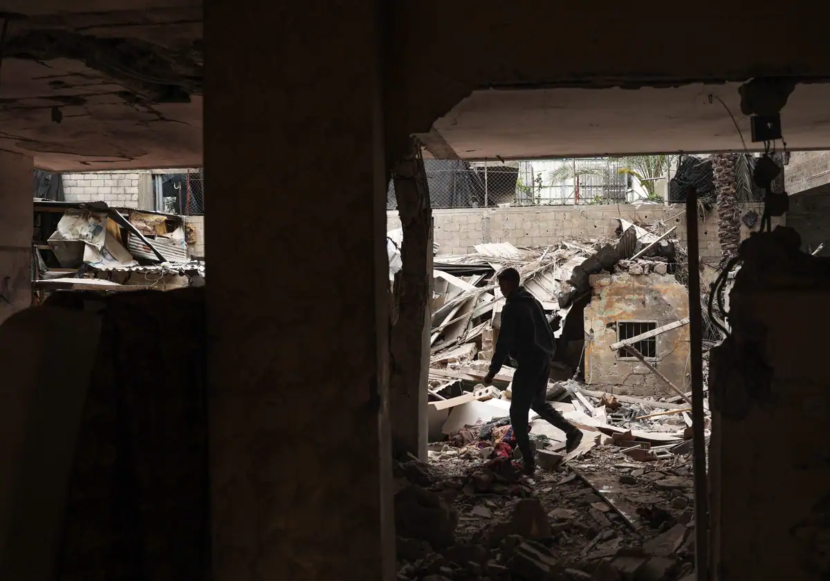 Un hombre examina los daños en una casa destruida por el bombardeo israelí nocturno en Rafah.