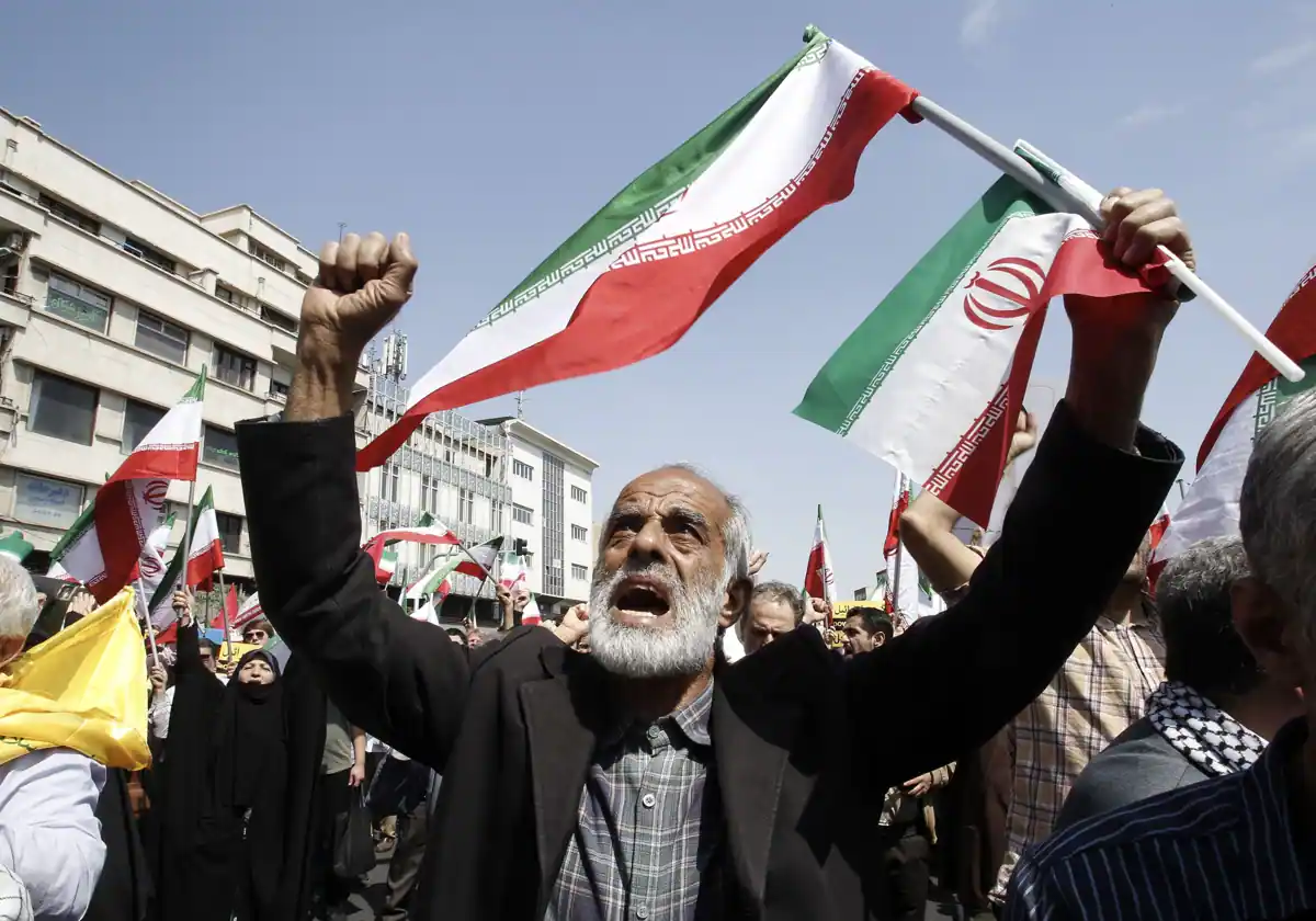 Los iraníes gritan consignas y ondan banderas iraníes durante una manifestación contra Israel en Teherán, Irán