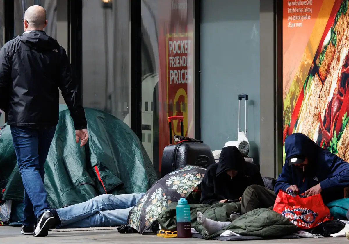 Un grupo de personas sin hogar juntas en una tienda de comestibles de Londres.